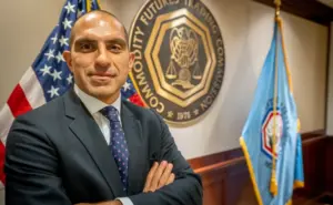 Autoritativni Rostin Behnam u formalnom okruženju s oznakama CFTC i američkom zastavom.