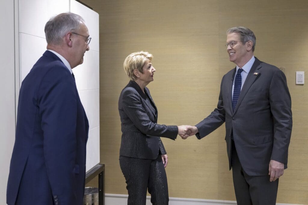 Tri osobe u formalnoj situaciji, prijateljski rukovanje i promatranje, poslovni sastanak.