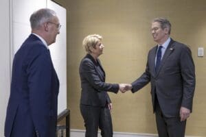 Tri osobe u formalnoj situaciji, prijateljski rukovanje i promatranje, poslovni sastanak.