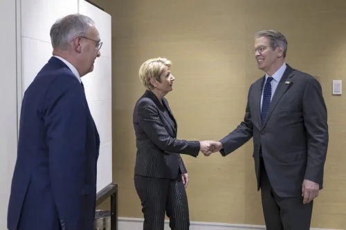 Tri osobe u formalnoj situaciji, prijateljski rukovanje i promatranje, poslovni sastanak.