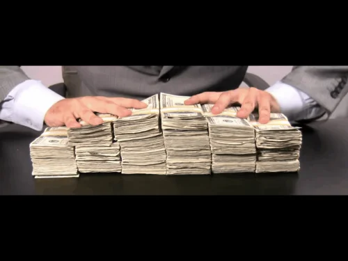 Hrpe američkih dolara s rukama u odijelu.Ljudska pohlepa